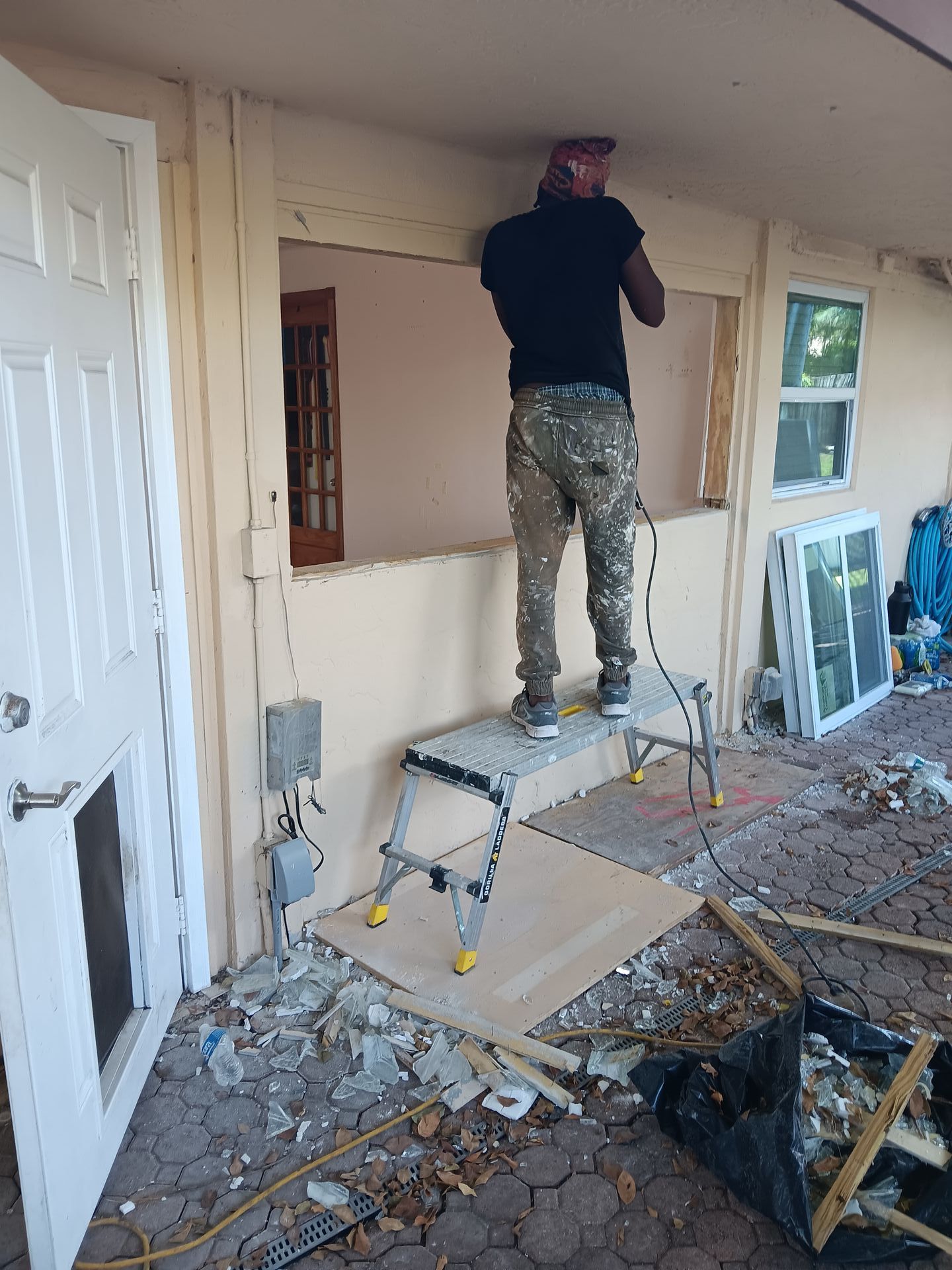A man is standing on a ladder in front of a door.