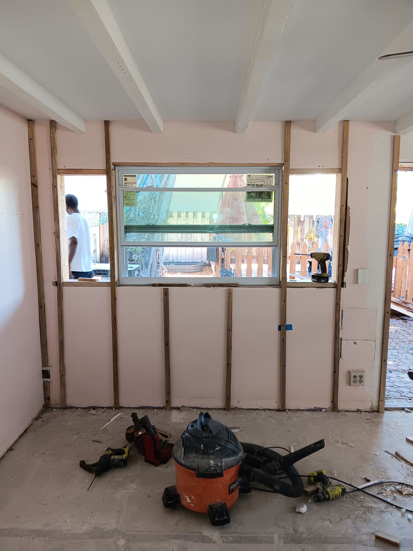 A room with a window and a vacuum cleaner in it.