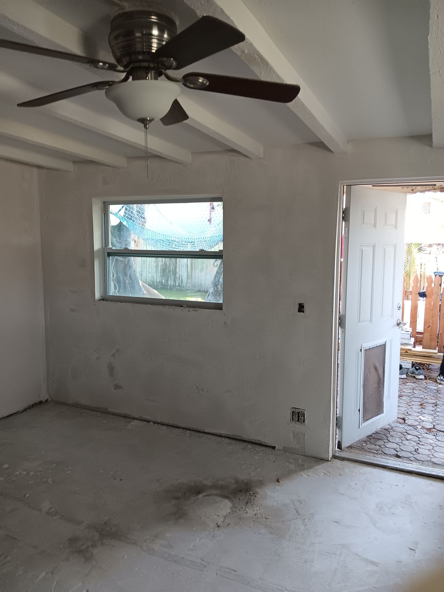 A room with a ceiling fan and a window