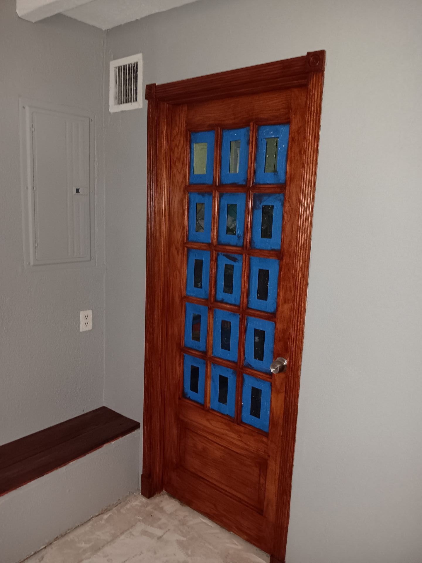 A wooden door with blue tape on it in a room.