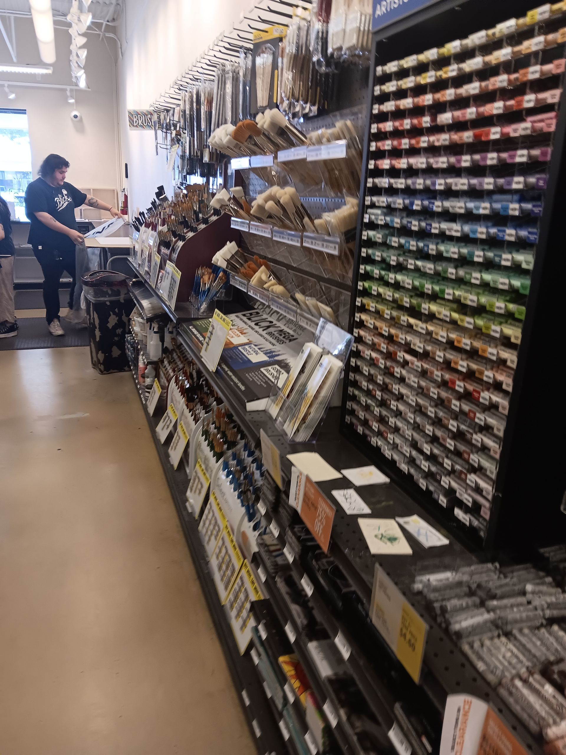 A woman is standing in front of a shelf in a store.