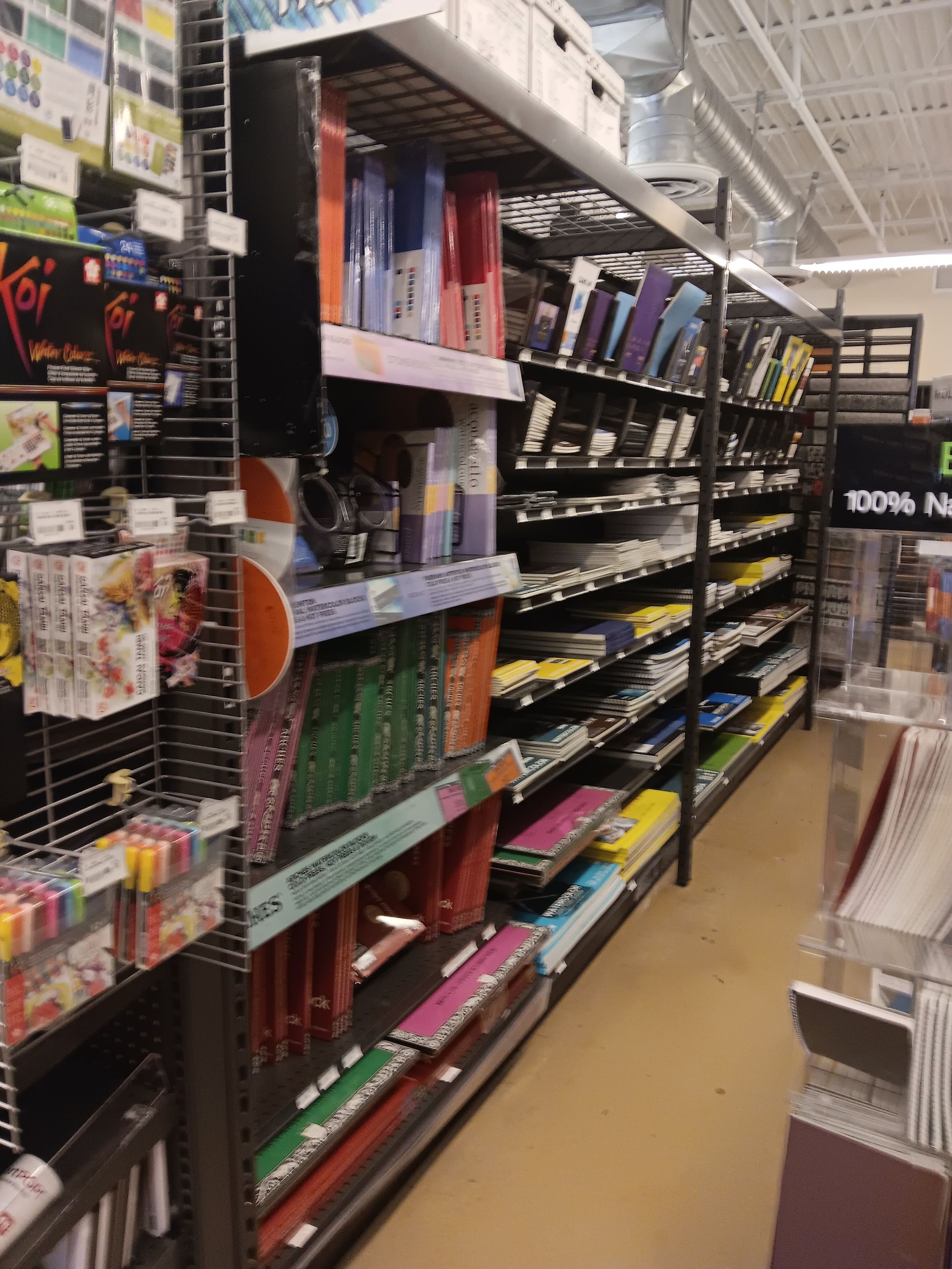 A store aisle with a sign that says 100 % new