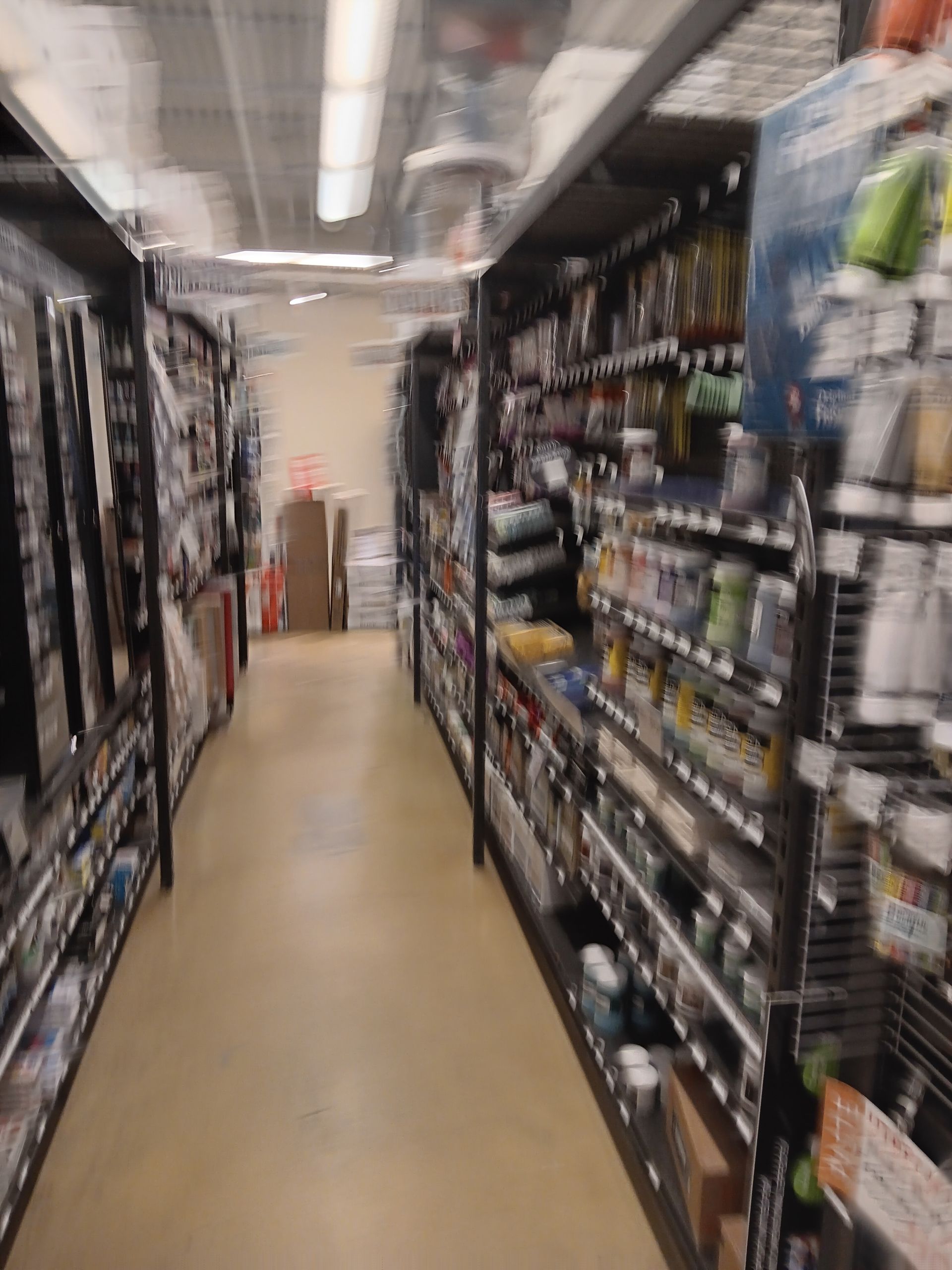A blurred image of a store aisle filled with lots of products.
