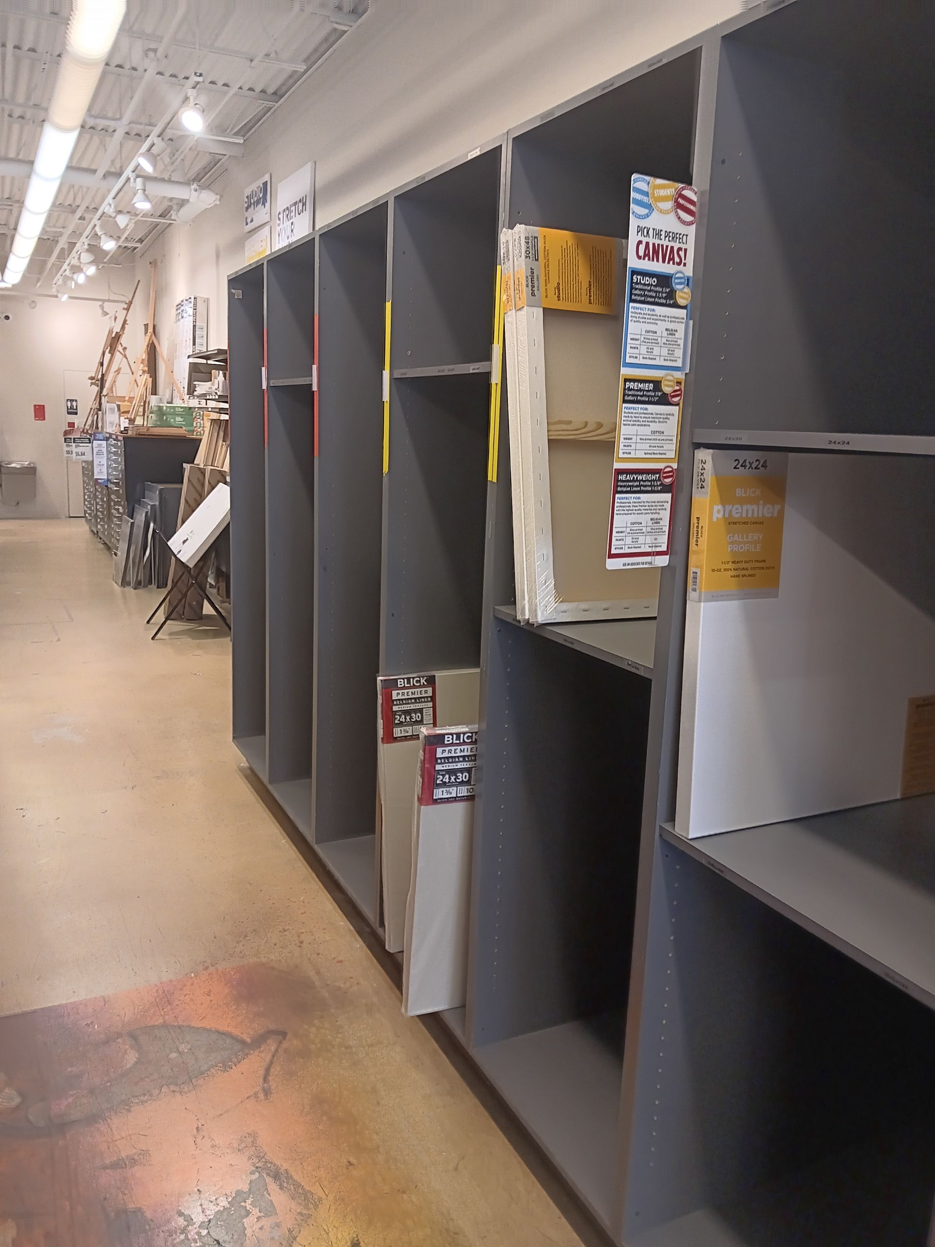 A row of empty shelves in a store with boxes on them.