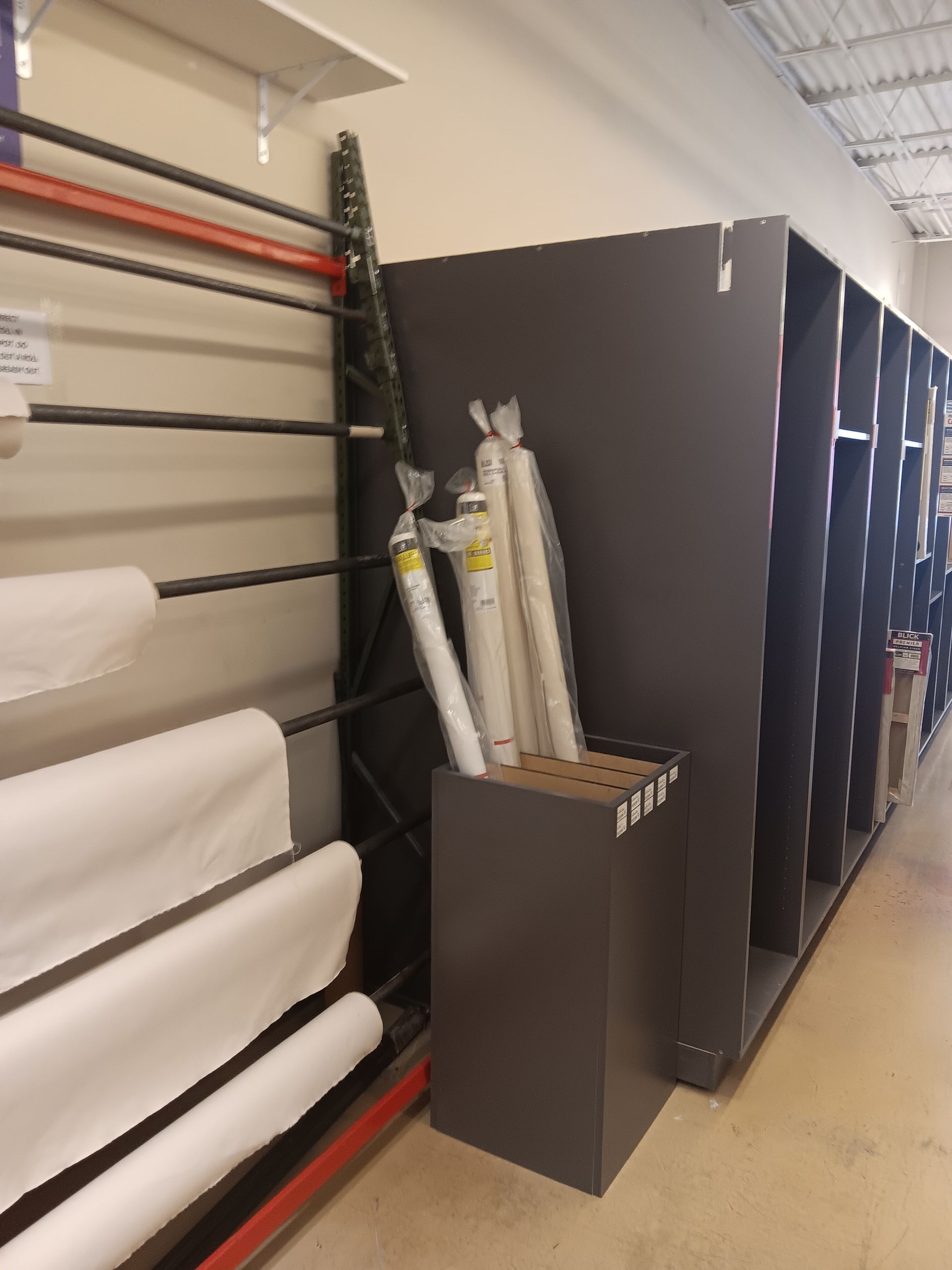 A row of shelves with rolls of fabric on them