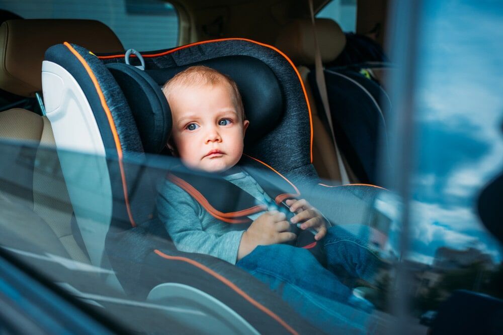 A Baby is Sitting in a car Seat in the back Seat of a car — Mechanical Services in Maroochydore, QLD