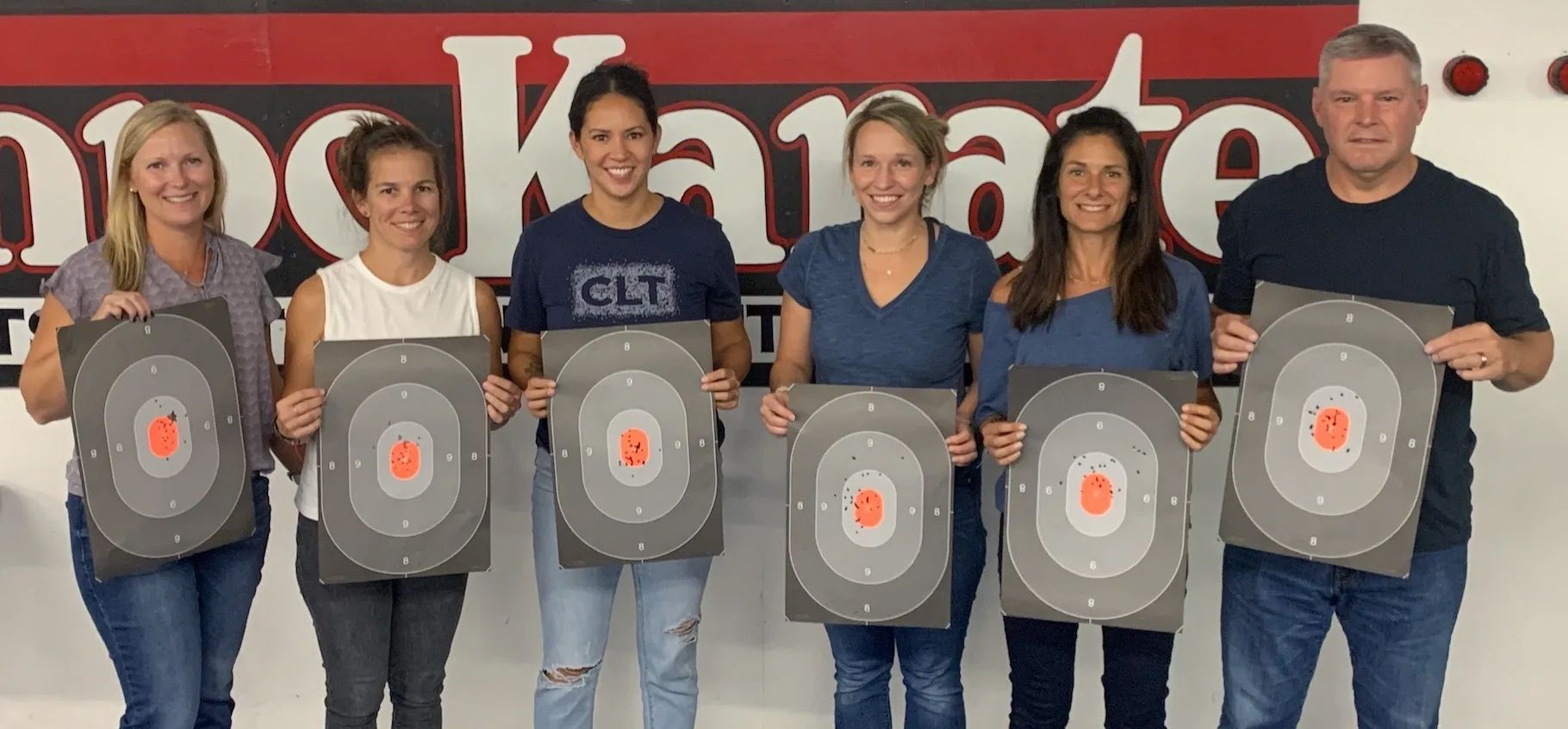 A Group Of People Are Standing Next To Each Other Holding Targets