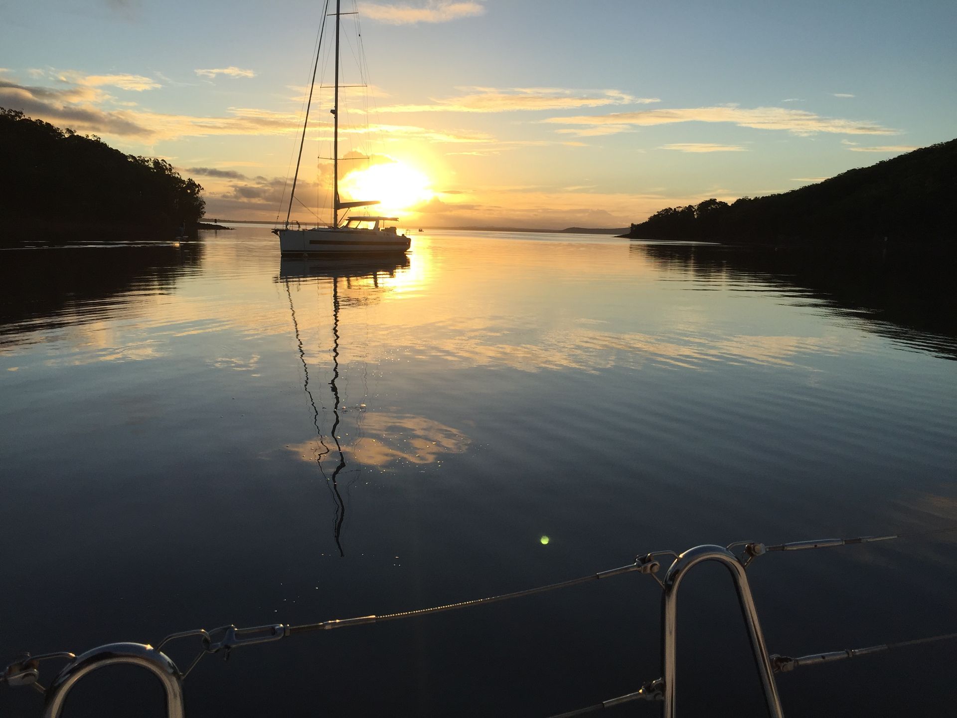 A boat is floating on a body of water at sunset