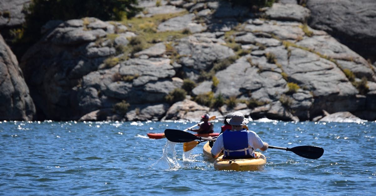 A group of people are paddling kayaks on a lake.