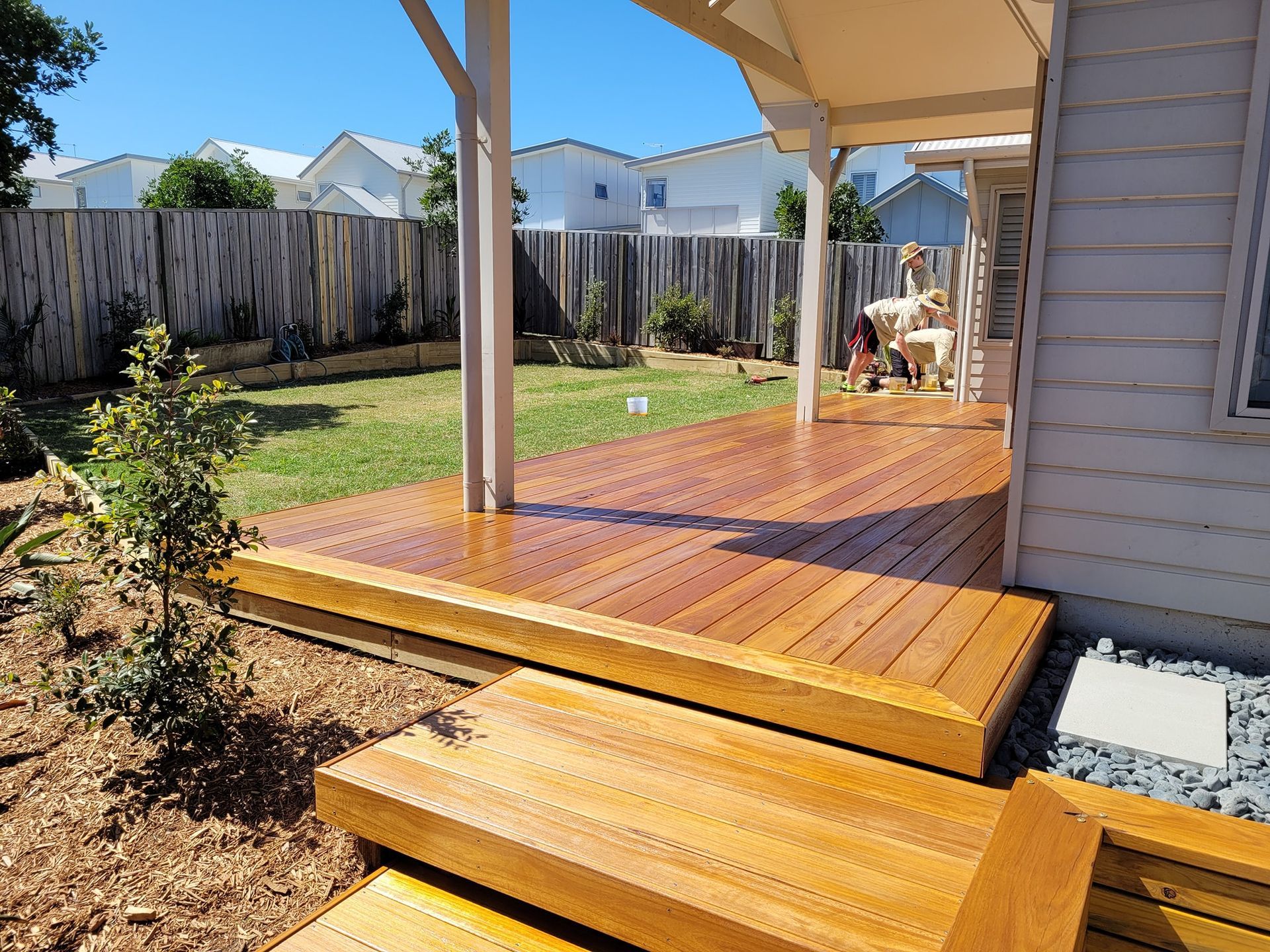 Group of Men Are Working on a Wooden Deck At The Back Of House— Red Dog Landscaping in Banora Point, NSW