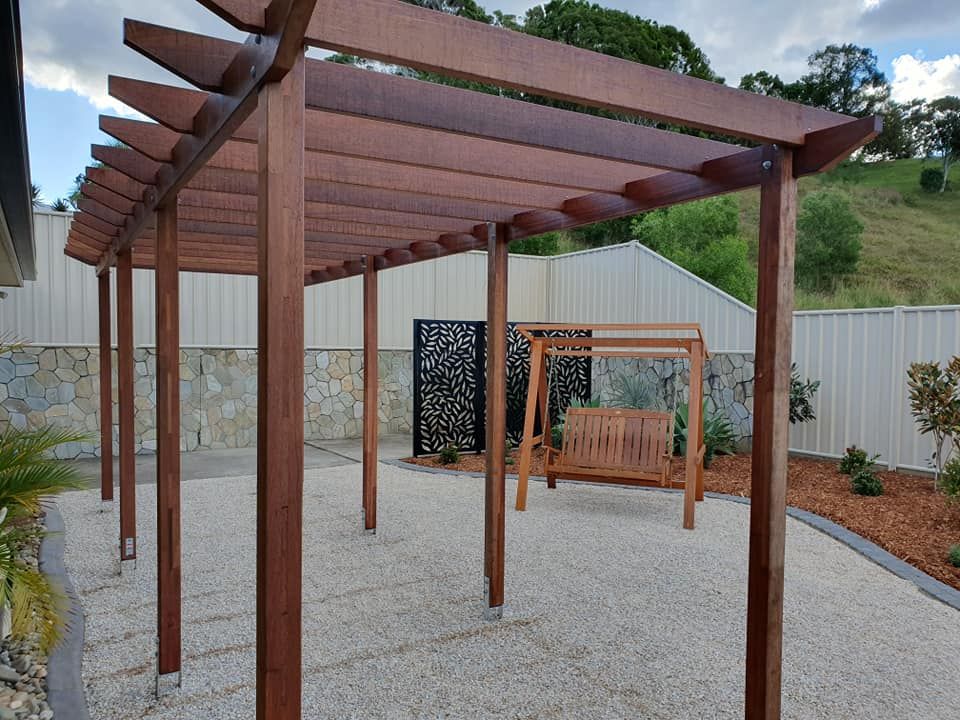 Landscaped Back Yard Wth Wooden Seat and Patio — Red Dog Landscaping in Tweed Heads, NSW