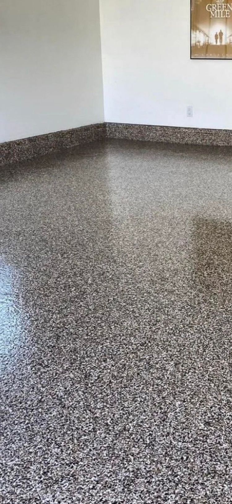 A room with a concrete floor and a picture on the wall
