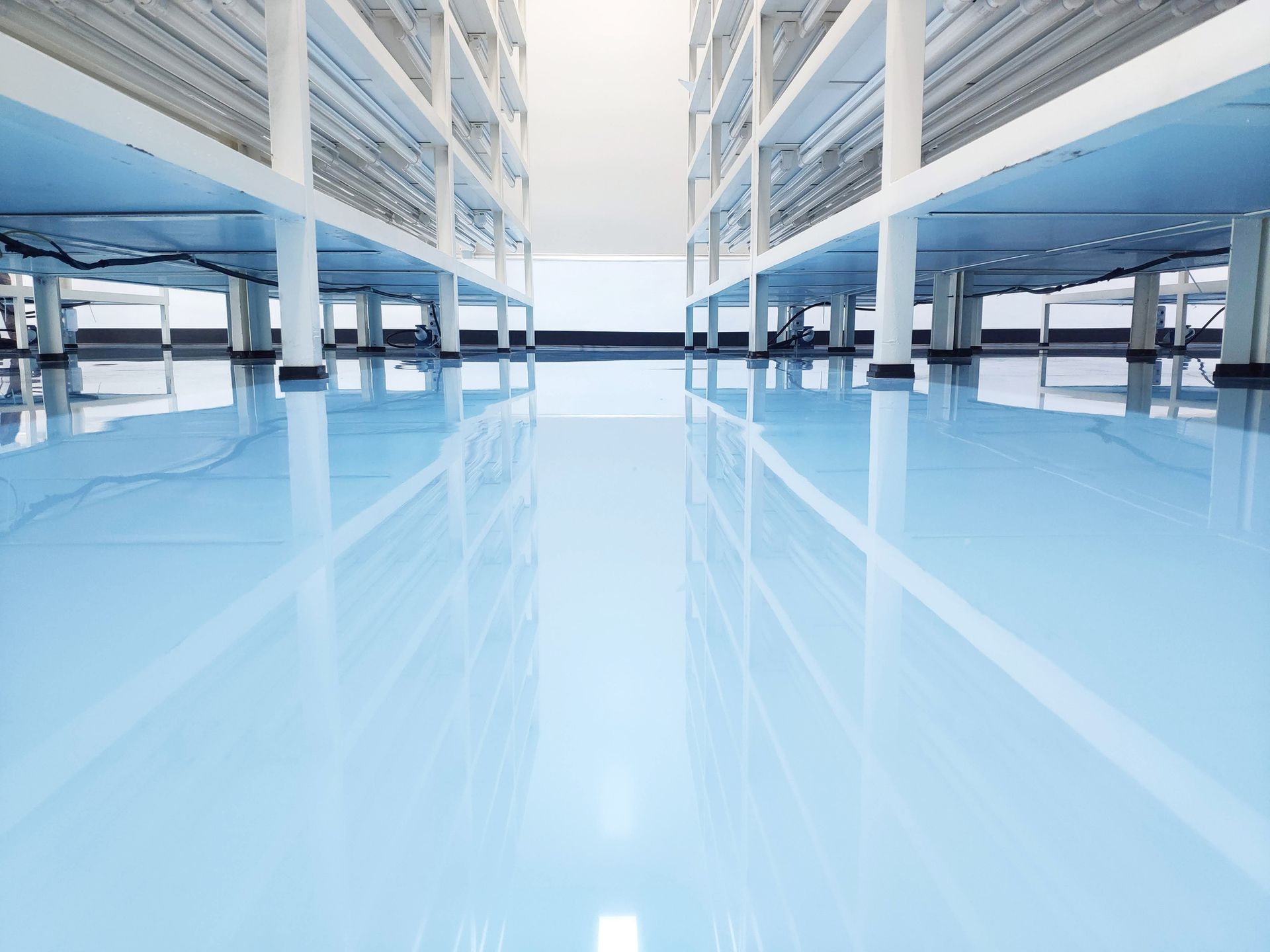A large empty parking garage with a shiny blue floor