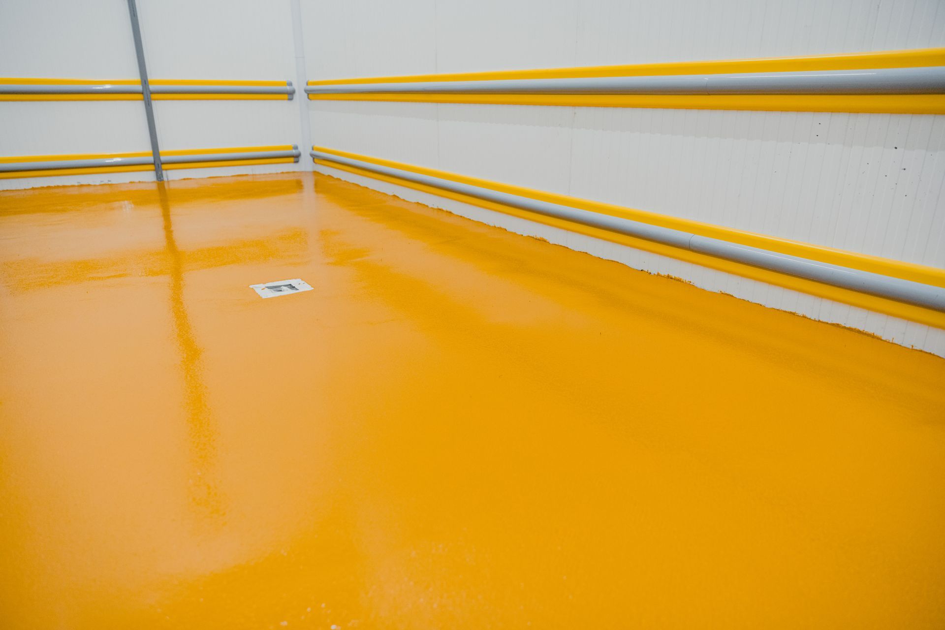 A room with a yellow floor and a white wall