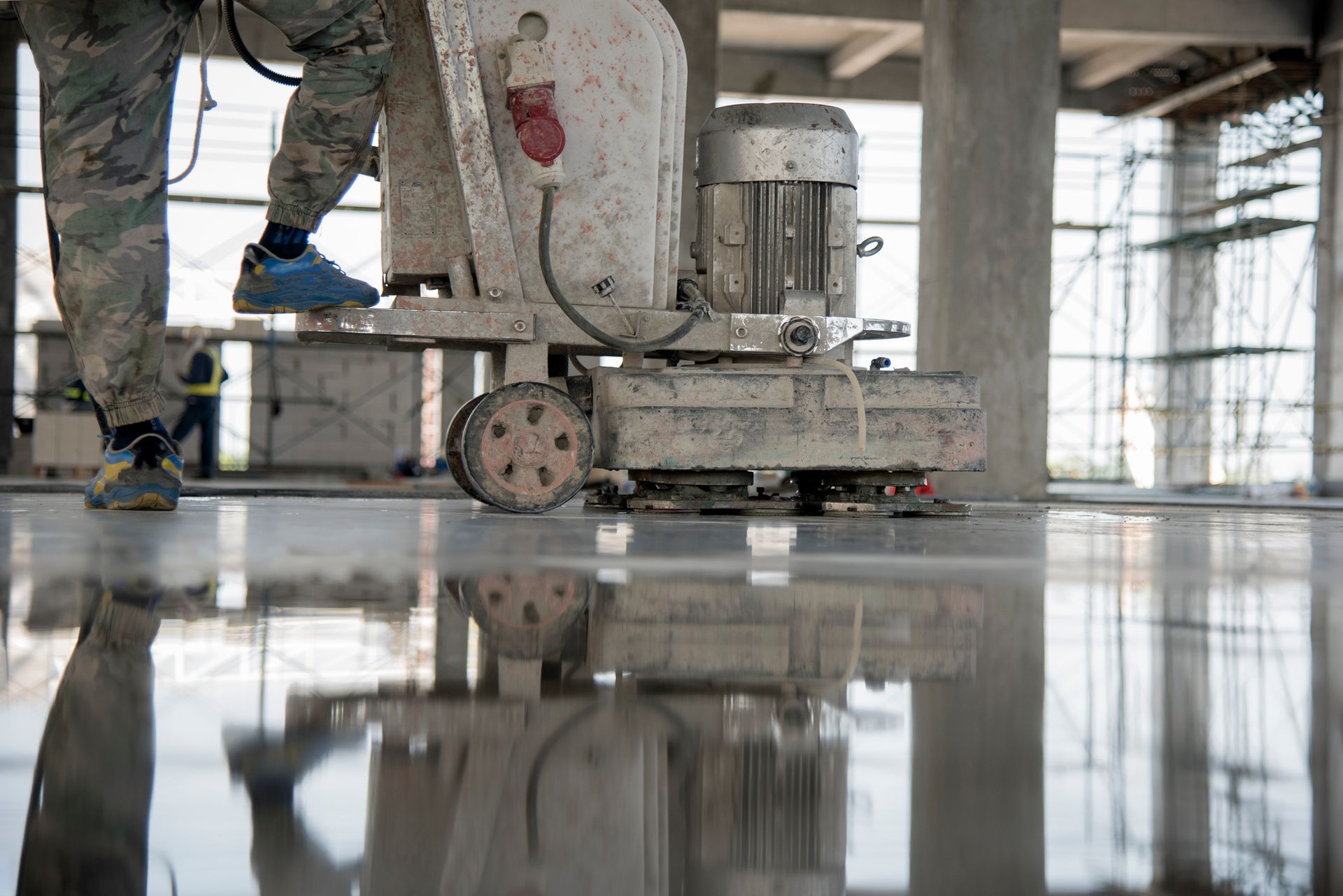 A man is polishing a concrete floor with a machine