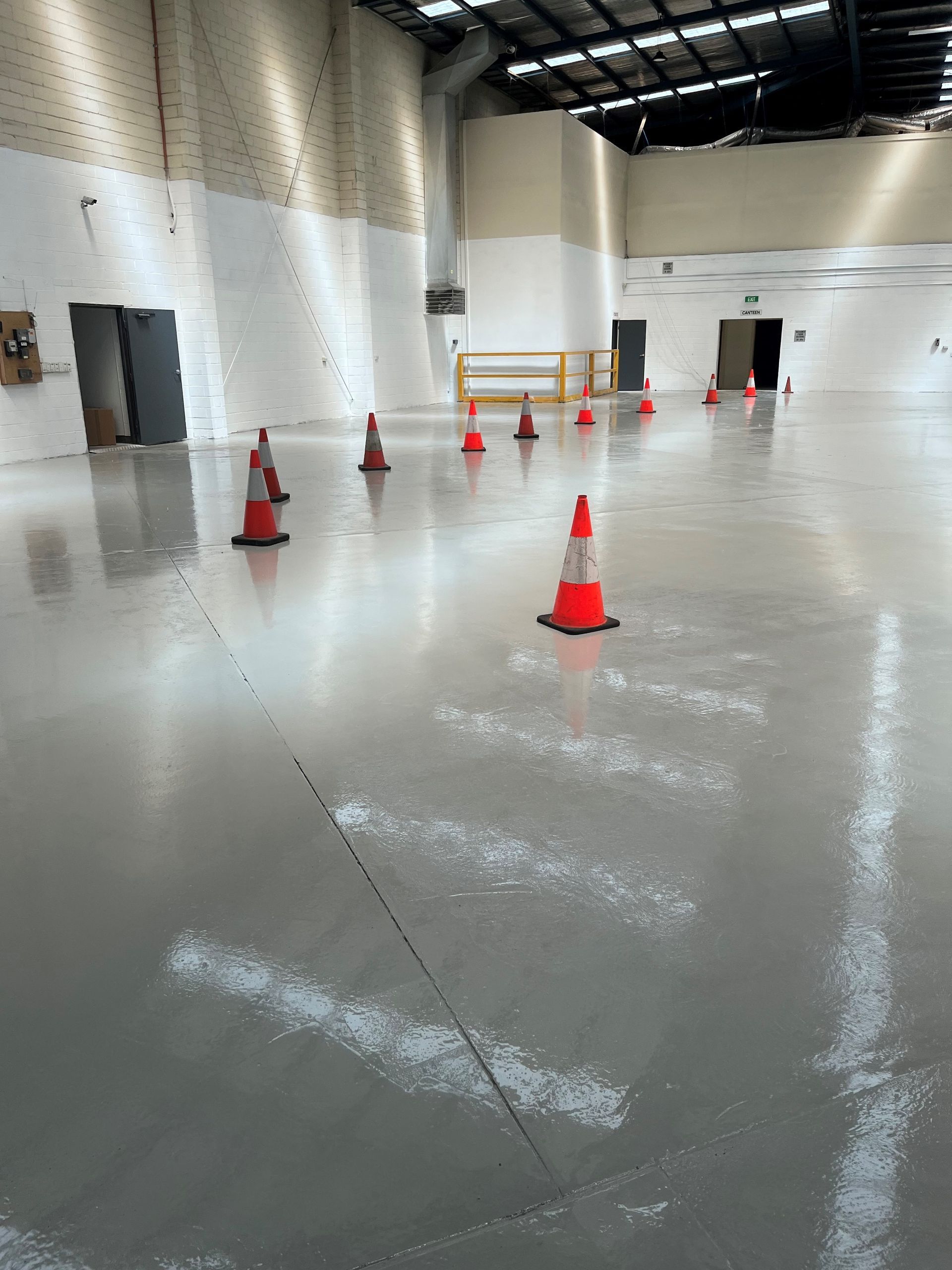 A warehouse with a lot of traffic cones on the floor