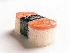 A close up of a piece of sushi on a white surface.