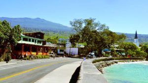 A road leading to a beach with mountains in the background.
