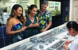 A group of people are looking at jewelry in a store.