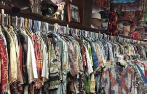 A store filled with lots of shirts hanging on racks.