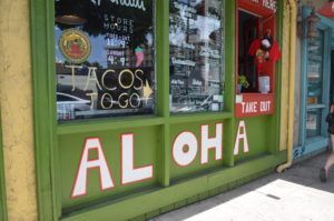 A green building with the word aloha painted on it