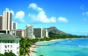 A beach with a mountain in the background and a city in the background.
