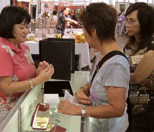 A woman in a pink shirt is talking to two other women