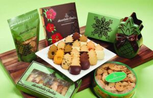 A variety of cookies are sitting on a wooden table.
