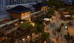 An aerial view of a shopping mall at night with people walking around.