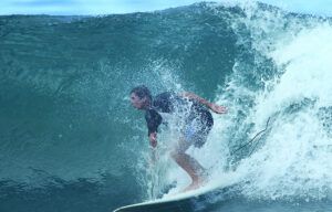 A man is riding a wave on a surfboard in the ocean.