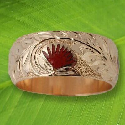 A gold ring is sitting on top of a green leaf.