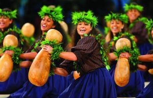 A group of women are dancing hula in a row.