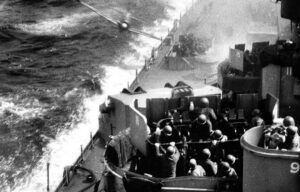 A black and white photo of a ship in the ocean.