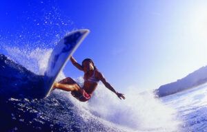 A woman is riding a wave on a surfboard in the ocean.