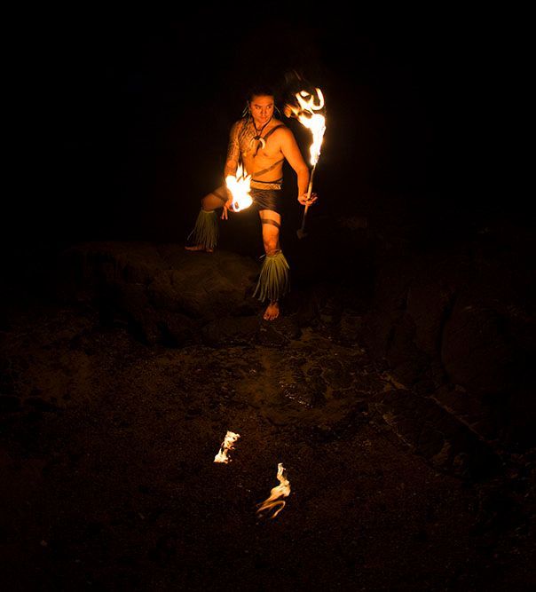 A man is holding a torch in the dark.