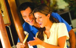A man and a woman are holding a hammer and smiling.