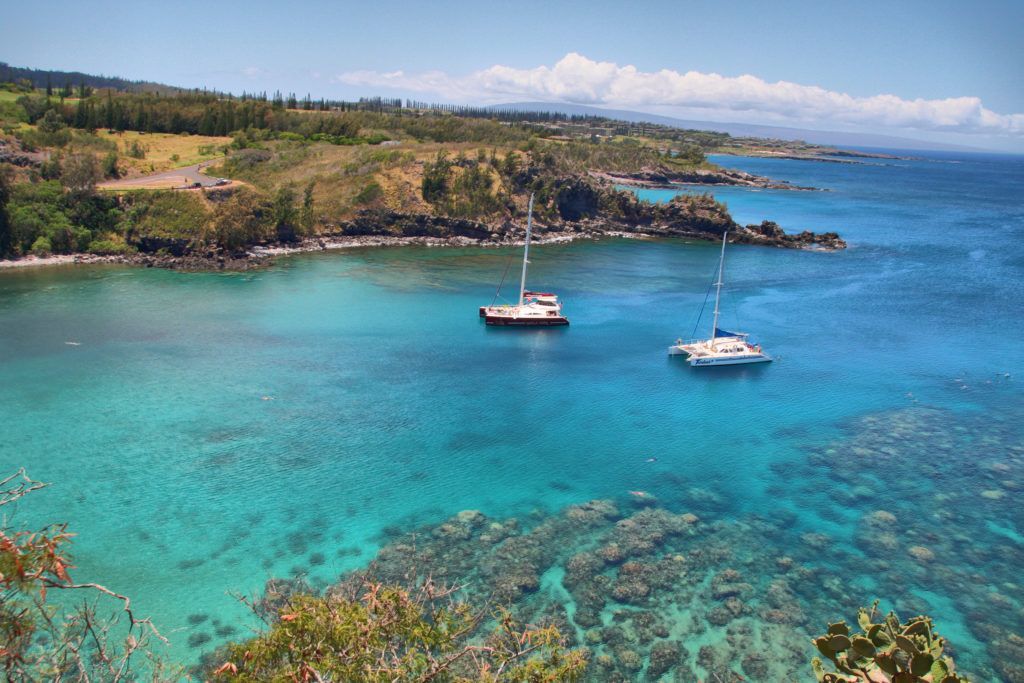 A couple of boats are floating on top of a body of water.