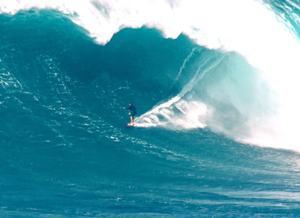 A man is riding a wave on a surfboard in the ocean.
