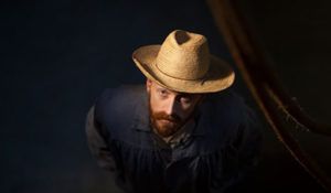 A man with a beard is wearing a cowboy hat.