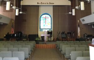 A church with a stained glass window that says be a friend of the nations