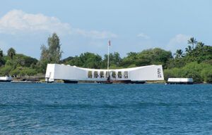 A large white building is sitting in the middle of a body of water.
