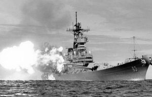 A black and white photo of a military ship in the ocean.