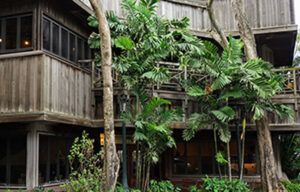 A large wooden house with lots of windows and trees in front of it.