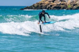 A man is riding a wave on a surfboard in the ocean.