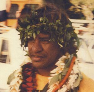 A man wearing a lei and leaves on his head