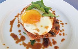 A close up of a plate of food with a fried egg on top.