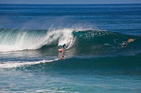 A person is riding a wave on a surfboard in the ocean.