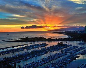 An aerial view of a marina with boats docked at sunset.