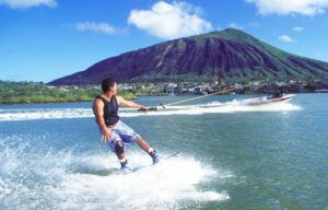 A man is water skiing in a lake with a mountain in the background