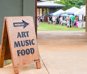A wooden sign that says more art music food